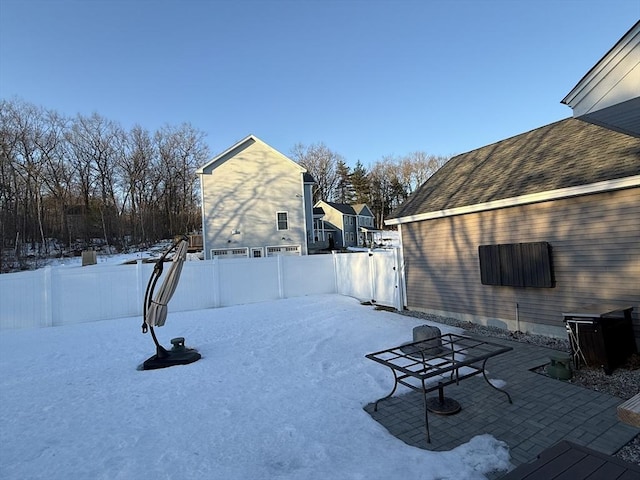 yard covered in snow featuring a patio area and fence