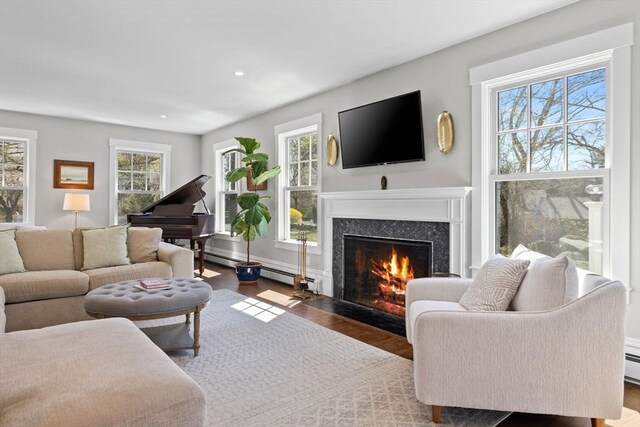 living area with a premium fireplace, recessed lighting, and wood finished floors