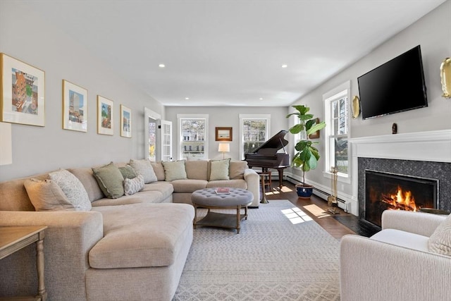 living area with recessed lighting, a high end fireplace, and dark wood-type flooring