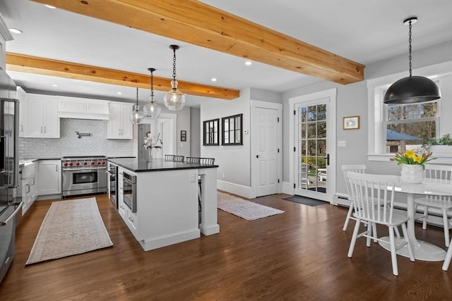 kitchen featuring beam ceiling, stainless steel stove, recessed lighting, a center island, and backsplash