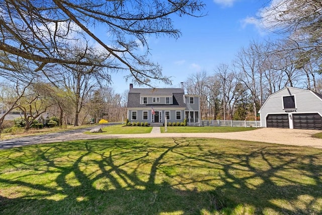exterior space featuring a chimney, a front yard, fence, an outdoor structure, and a gambrel roof