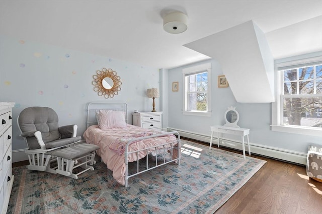 bedroom featuring multiple windows, wood finished floors, and a baseboard radiator