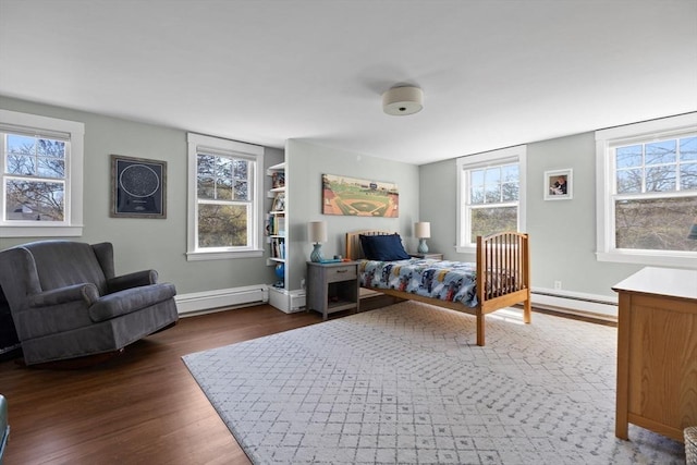 bedroom with baseboards, a baseboard radiator, wood finished floors, and baseboard heating