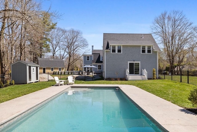 rear view of property featuring an outdoor structure, a patio, a fenced backyard, a storage unit, and a lawn