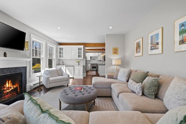 living room featuring recessed lighting, a high end fireplace, dark wood-style flooring, and baseboard heating