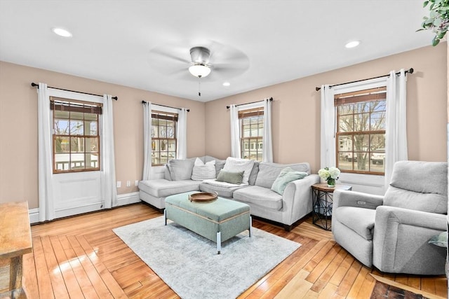 living area featuring baseboards, recessed lighting, a ceiling fan, and light wood-style floors