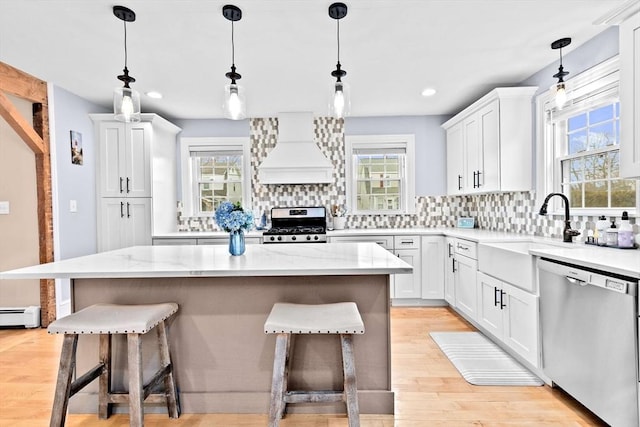 kitchen featuring a breakfast bar, custom exhaust hood, stainless steel appliances, and decorative backsplash