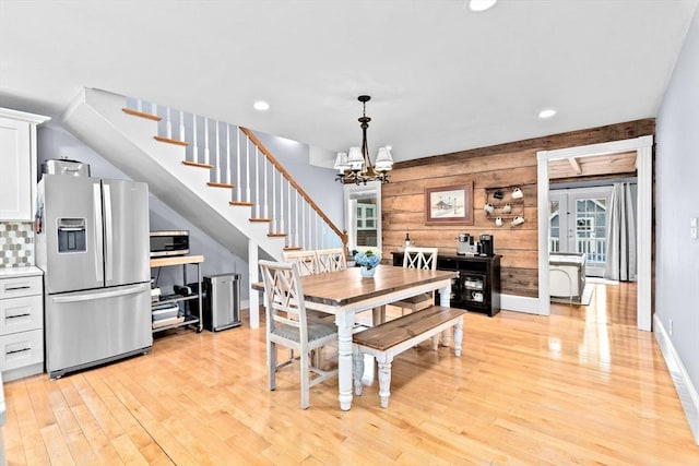 dining area with stairs, wood walls, light wood-style floors, a chandelier, and recessed lighting