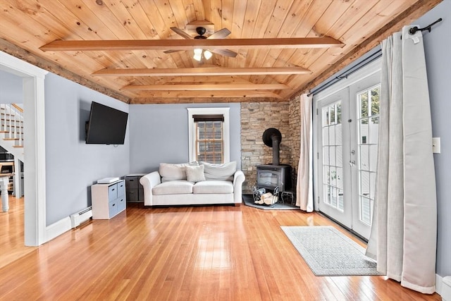 unfurnished living room with a baseboard heating unit, wood ceiling, french doors, stairway, and a wood stove