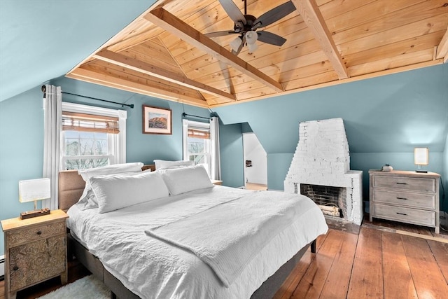 bedroom featuring lofted ceiling with beams, hardwood / wood-style floors, wooden ceiling, and a brick fireplace