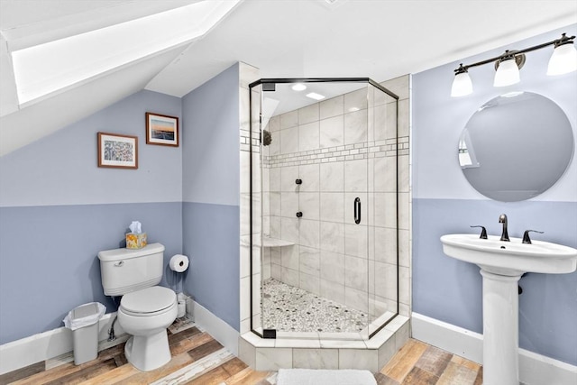 bathroom featuring vaulted ceiling, a stall shower, wood finished floors, and toilet