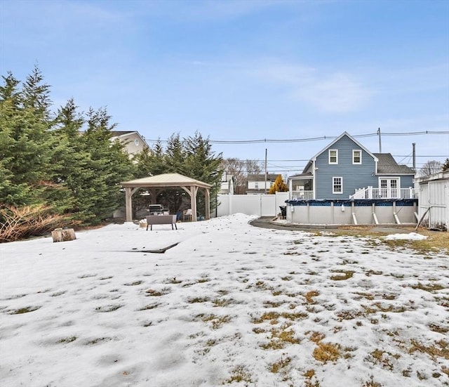 yard covered in snow with a fenced in pool, fence, and a gazebo