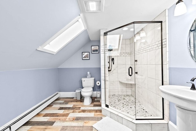 full bathroom featuring toilet, lofted ceiling with skylight, a baseboard radiator, wood finished floors, and a shower stall