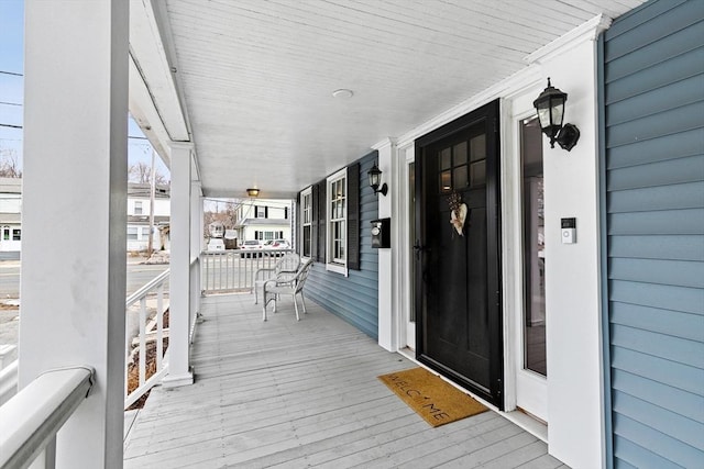 view of exterior entry featuring covered porch