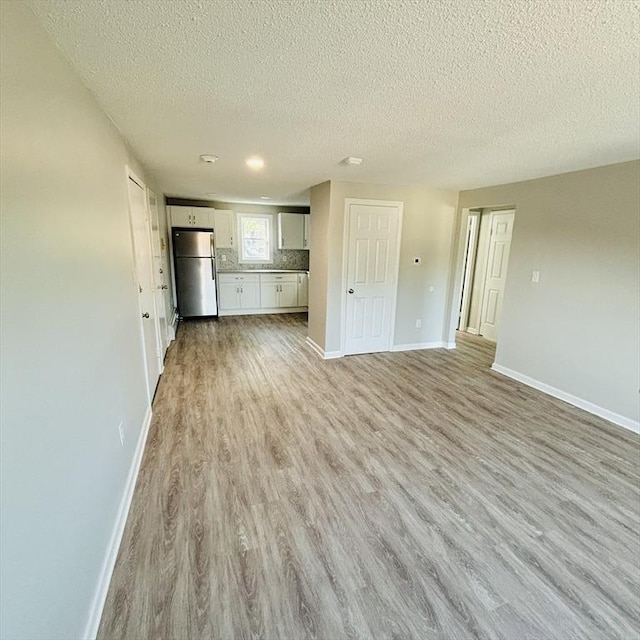 16A Exeter St, Lawrence, MA 01843 - unfurnished living room featuring a textured ceiling and light wood finished floors