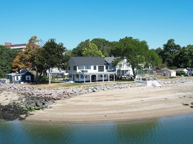 back of house featuring a water view and a beach view