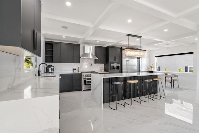 kitchen featuring a kitchen island, wall chimney exhaust hood, decorative light fixtures, and high end appliances