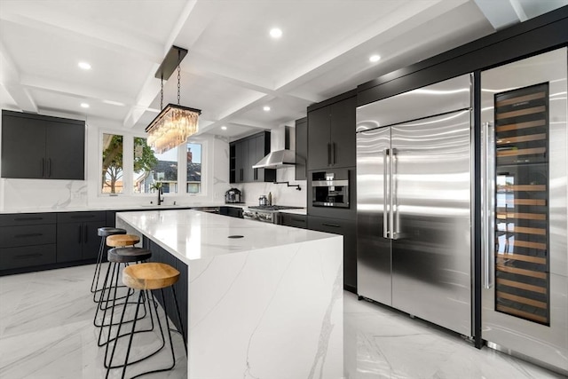 kitchen featuring a center island, a breakfast bar area, hanging light fixtures, modern cabinets, and wall chimney exhaust hood