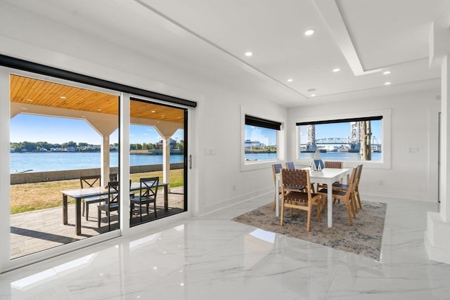 dining space featuring baseboards, recessed lighting, marble finish floor, and a water view