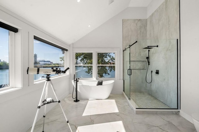 bathroom featuring marble finish floor, a freestanding tub, lofted ceiling, and a shower stall