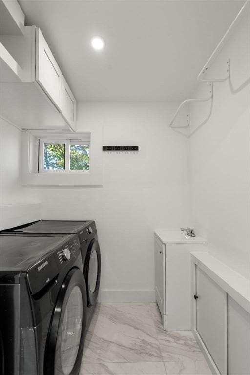 washroom with marble finish floor, cabinet space, baseboards, a sink, and washing machine and clothes dryer