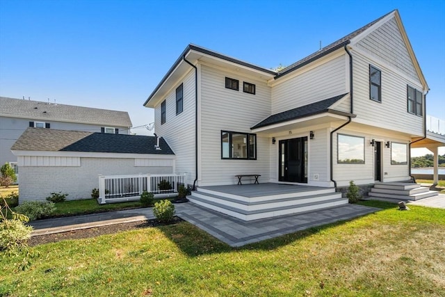 rear view of property featuring a lawn and covered porch