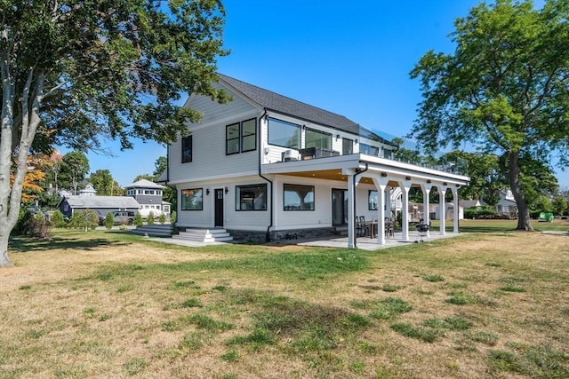 view of front of home featuring a balcony, a patio area, and a front yard