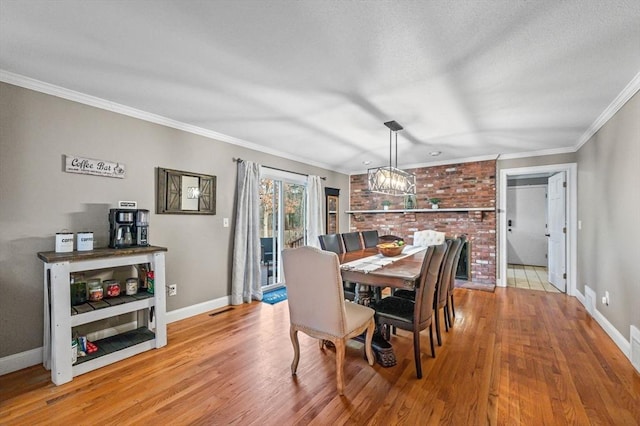 dining area with ornamental molding and light hardwood / wood-style floors