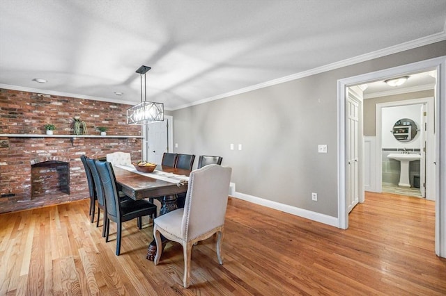 dining space with ornamental molding, light hardwood / wood-style flooring, and sink