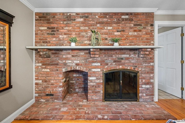 interior details with a fireplace, ornamental molding, and hardwood / wood-style flooring