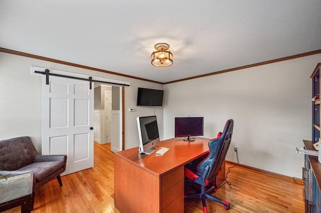 office area featuring ornamental molding, light wood-type flooring, and a barn door