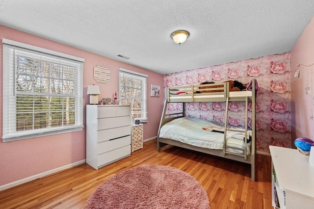 bedroom with a textured ceiling and light hardwood / wood-style floors