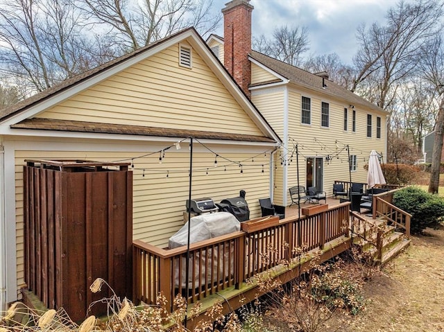 rear view of property featuring a wooden deck