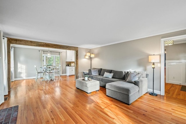 living room featuring ornamental molding and light hardwood / wood-style floors