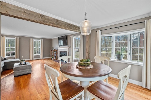 dining area featuring light wood-type flooring and crown molding