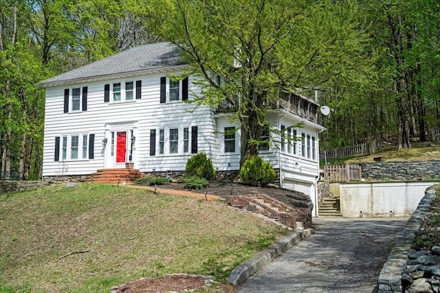colonial inspired home featuring an attached garage, driveway, and entry steps