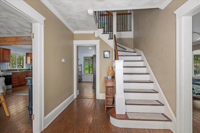 stairs featuring baseboards, crown molding, and hardwood / wood-style flooring