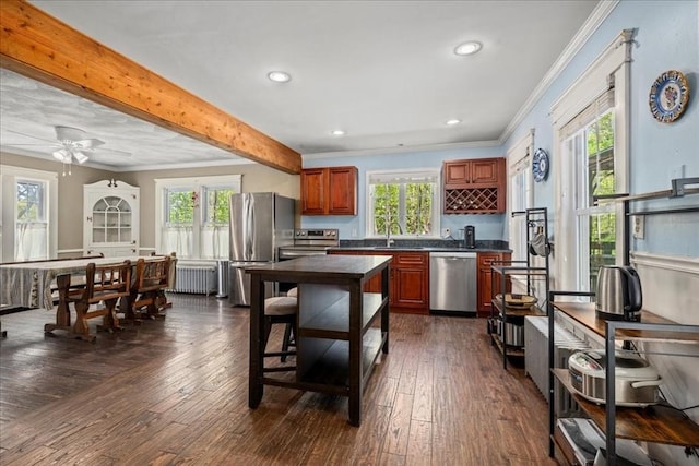 kitchen featuring crown molding, dark countertops, radiator heating unit, a sink, and appliances with stainless steel finishes