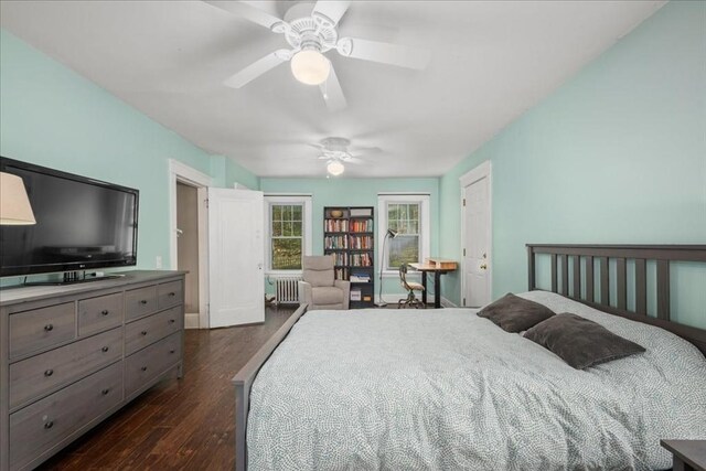 bedroom with radiator heating unit, baseboards, ceiling fan, and dark wood-type flooring
