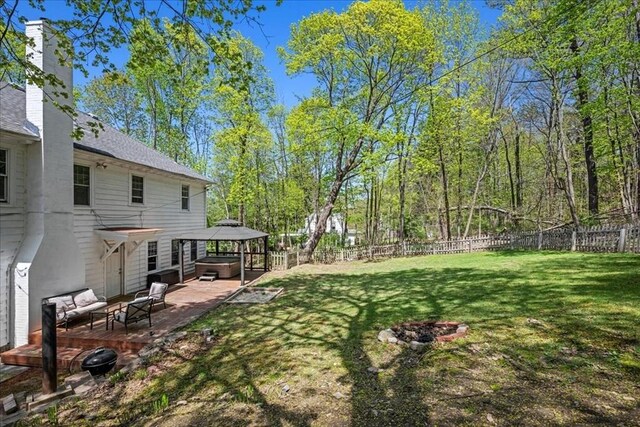view of yard with a deck, a hot tub, a gazebo, a fenced backyard, and outdoor lounge area
