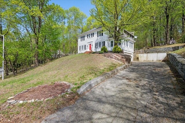 colonial inspired home with a front lawn and aphalt driveway