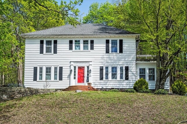colonial inspired home featuring a front lawn