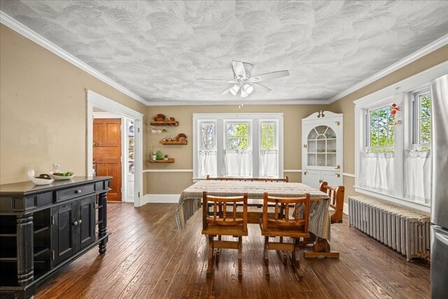 dining room featuring crown molding, ceiling fan, radiator, baseboards, and dark wood-type flooring
