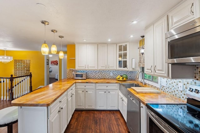 44 Drexel St, Worcester, MA 01602 - kitchen with stainless steel appliances, wood counters, a peninsula, dark wood finished floors, and recessed lighting