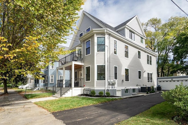 view of home's exterior featuring an outbuilding, a balcony, and cooling unit