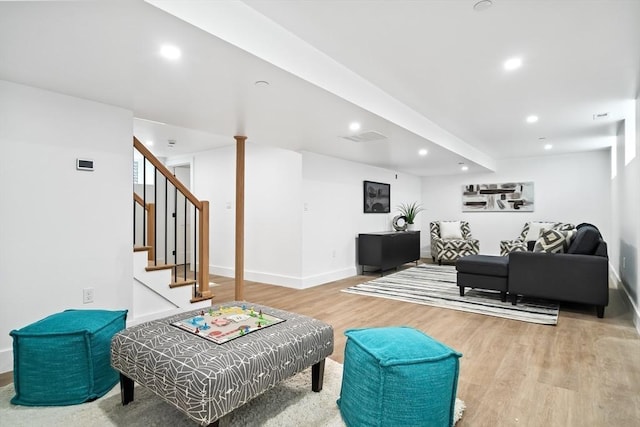 living area featuring recessed lighting, baseboards, wood finished floors, visible vents, and stairway