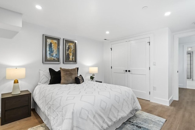 bedroom featuring baseboards, a closet, recessed lighting, and wood finished floors