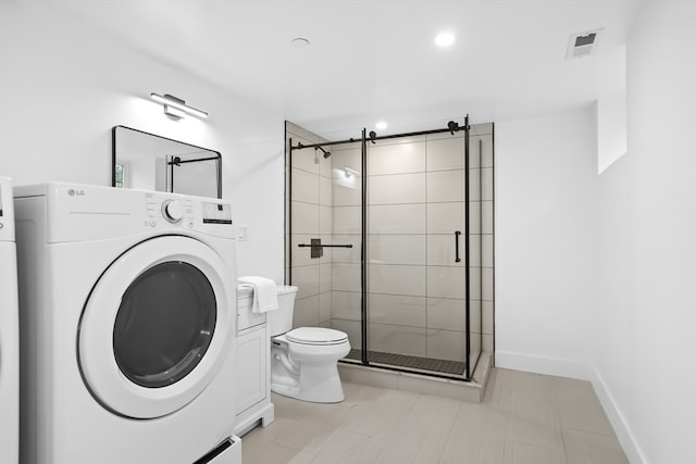 bathroom with washer / dryer, toilet, and an enclosed shower