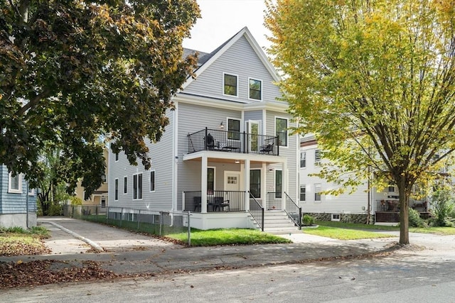 greek revival house featuring a porch, fence private yard, and a balcony