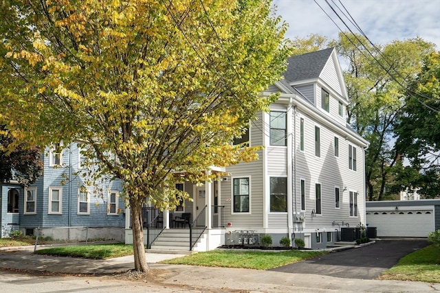 view of front of house featuring central AC, a garage, and an outbuilding